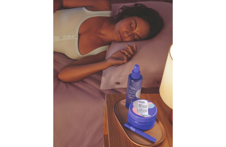 mulher dormindo com os produtos de Tododia Todanoite na mesinha ao lado da cama.